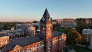 An aerial view of the Holy Cross campus that is centered on the clocktower of O’Kane Hall.