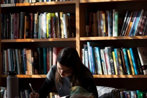 A close up image of a female student studying in a library environment.